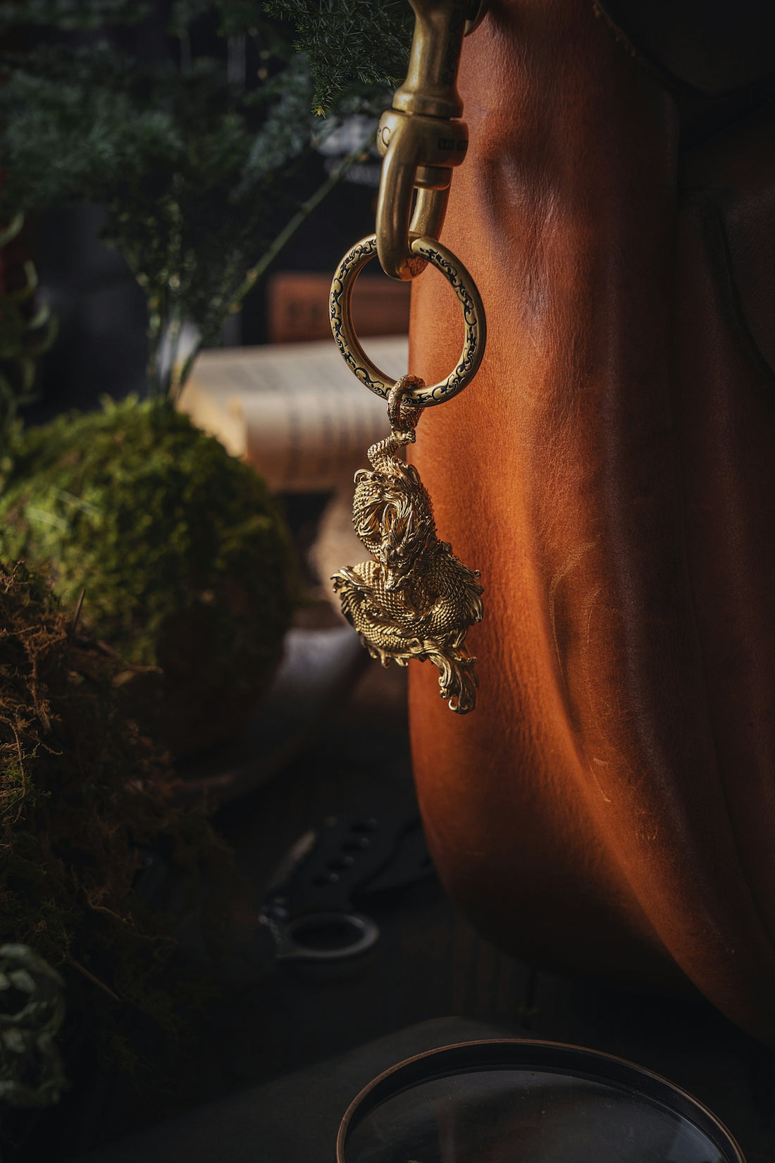 a golden lion keychain hanging from a leather purse