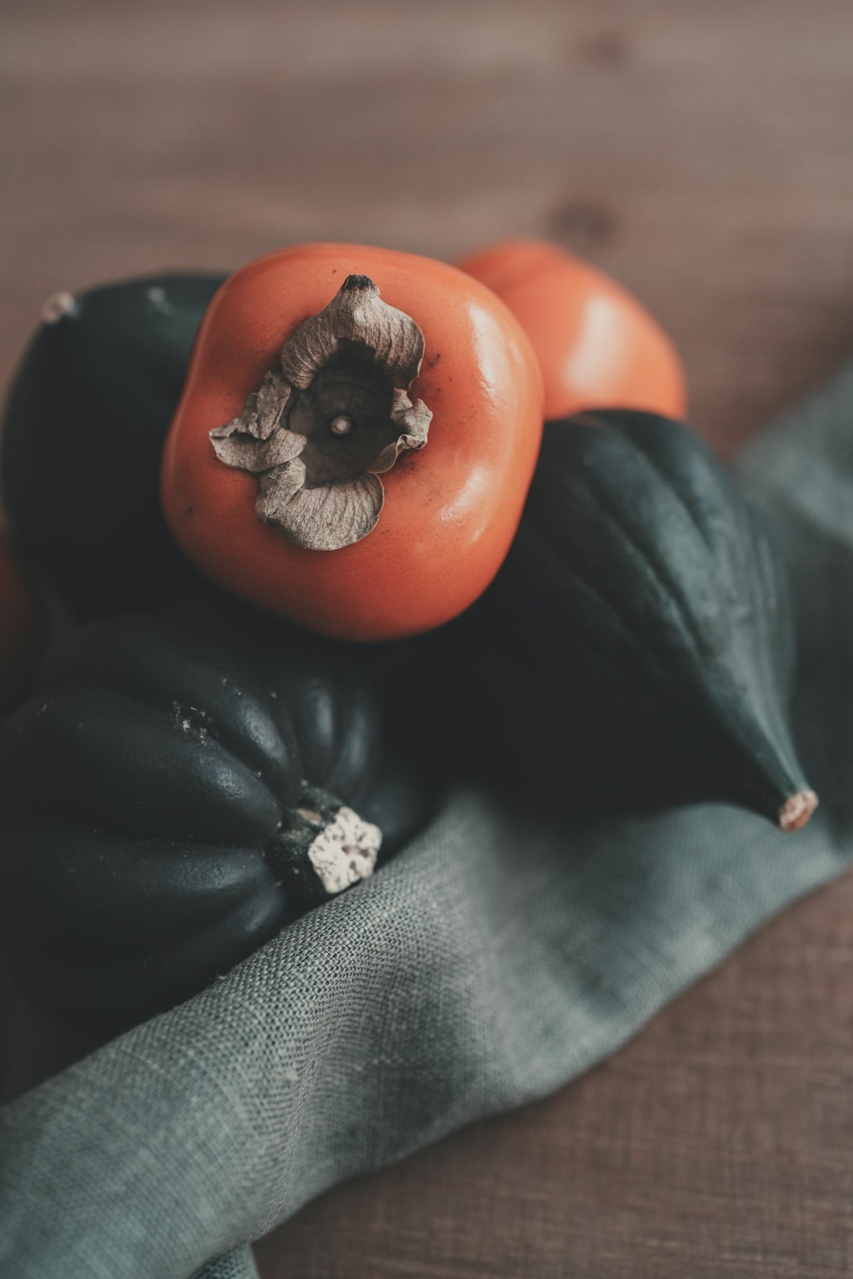 Orange persimmons and dark green acorn squash.